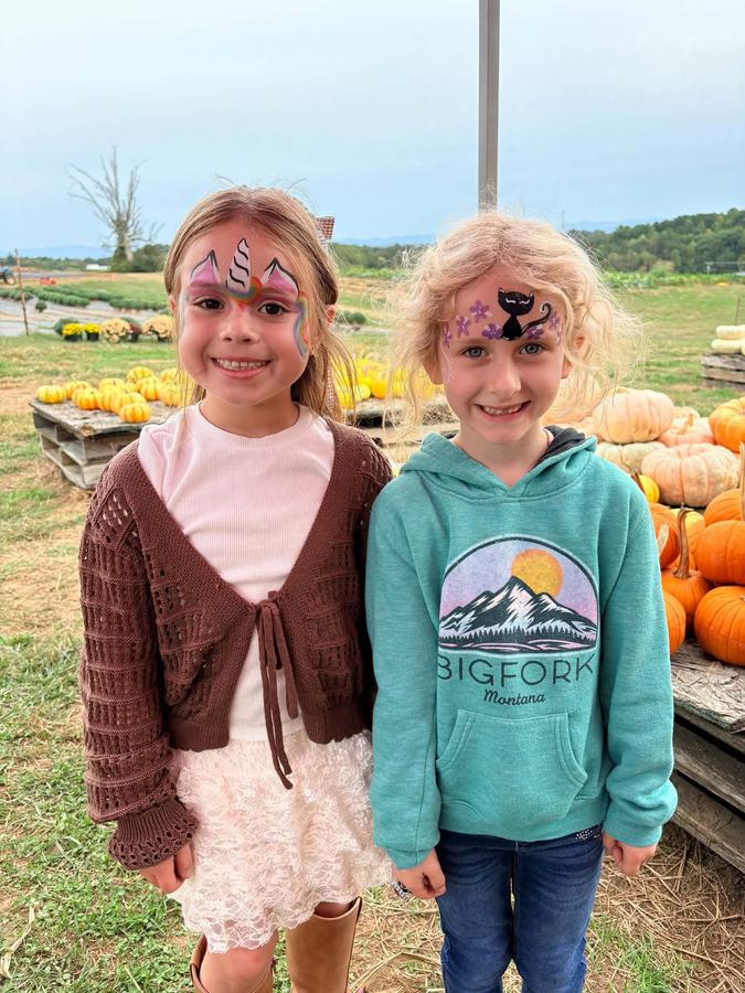 Two girls with unicorn and black cat face painting at a pumpkin patch, face painting by In His Image, Morristown TN